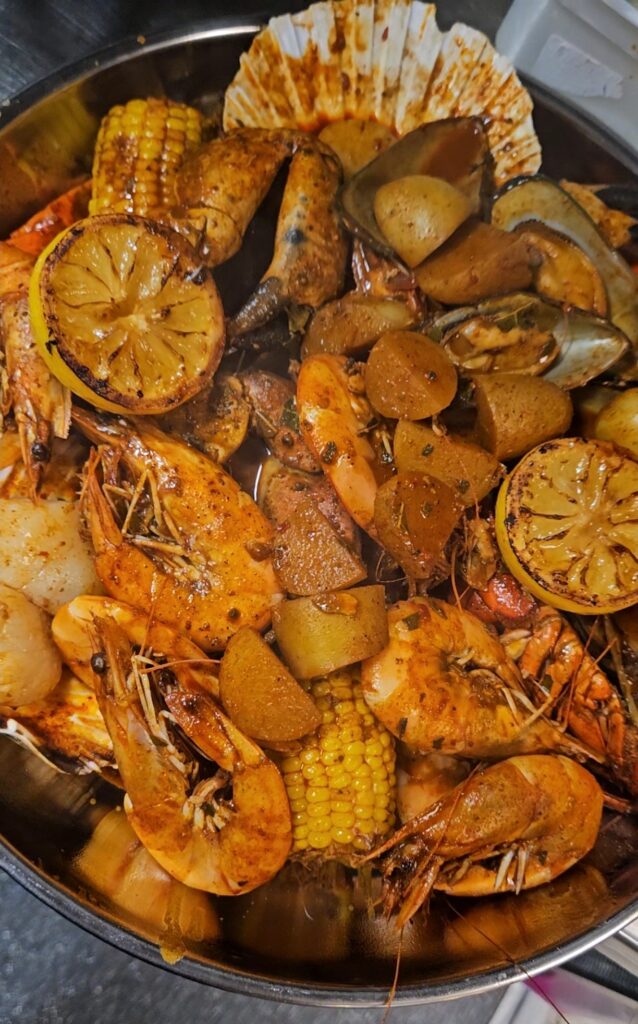 A vibrant seafood boil with crab, prawns, mussels and corn